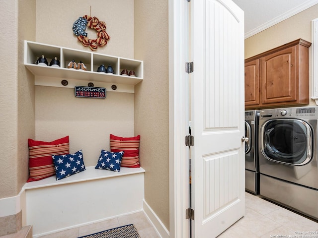 laundry area with cabinets, washer and clothes dryer, light tile patterned floors, and crown molding