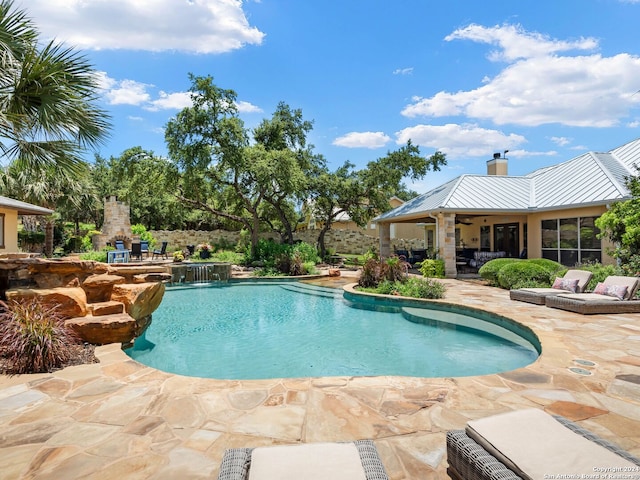 view of pool with an outdoor stone fireplace and a patio area