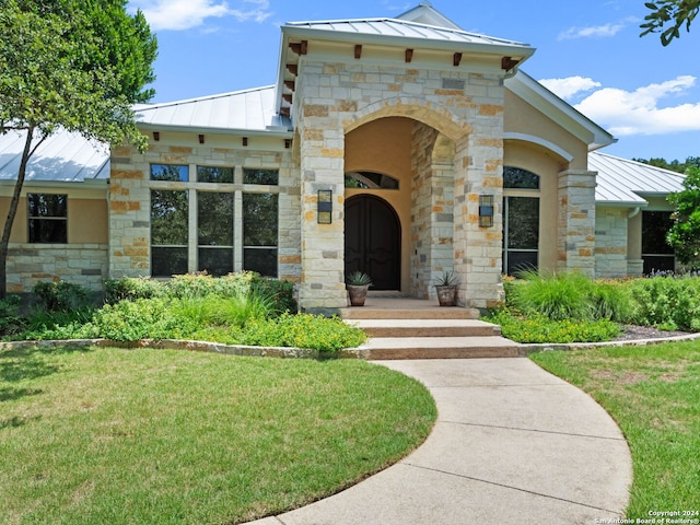 property entrance with a lawn