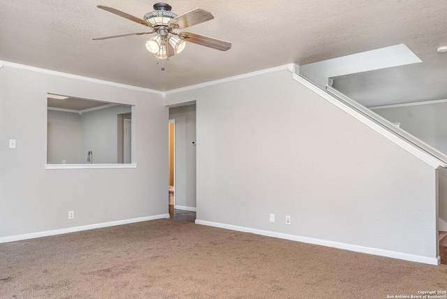 carpeted empty room featuring ceiling fan, ornamental molding, and a textured ceiling