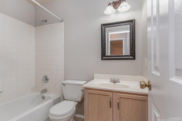 full bathroom featuring toilet, tiled shower / bath, and vanity