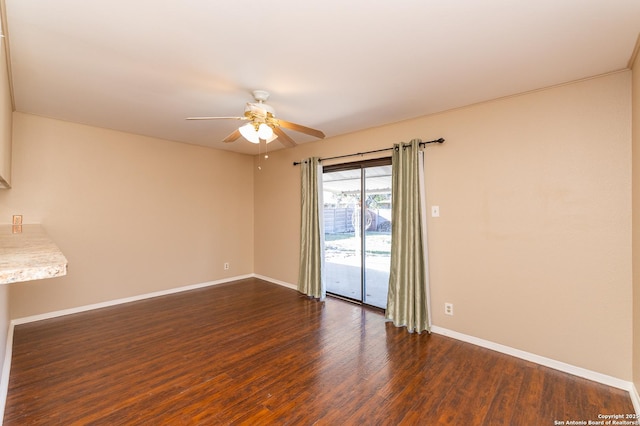 empty room with ceiling fan and dark hardwood / wood-style floors