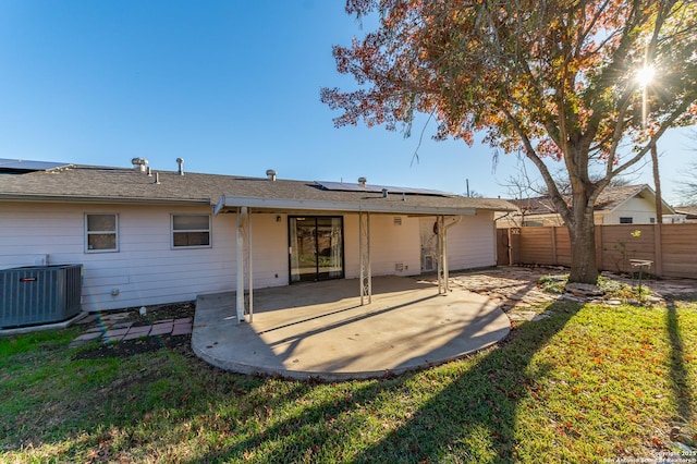 back of property with a patio area, central air condition unit, and a yard