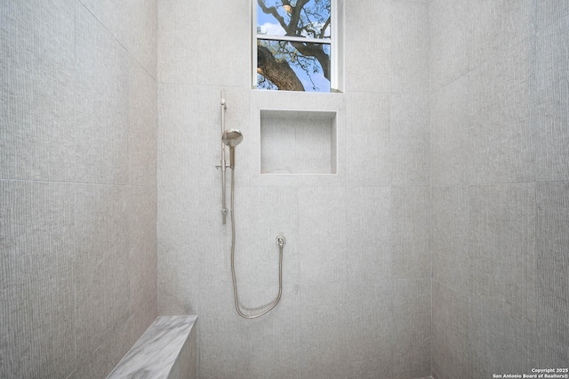 interior details featuring tiled shower