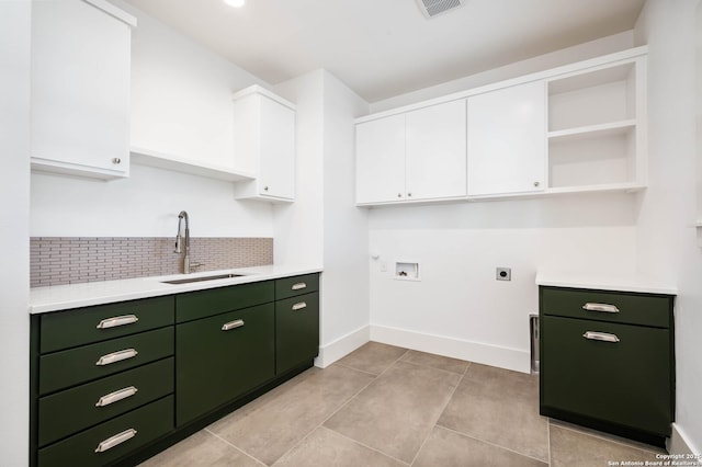 washroom with sink, hookup for a washing machine, cabinets, hookup for an electric dryer, and light tile patterned floors