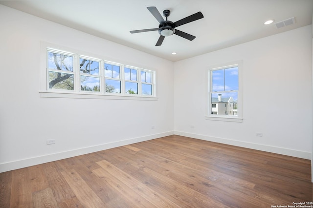 empty room with hardwood / wood-style floors and ceiling fan