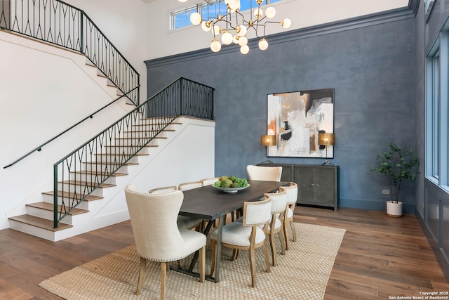 dining space featuring a high ceiling, an inviting chandelier, and dark hardwood / wood-style floors