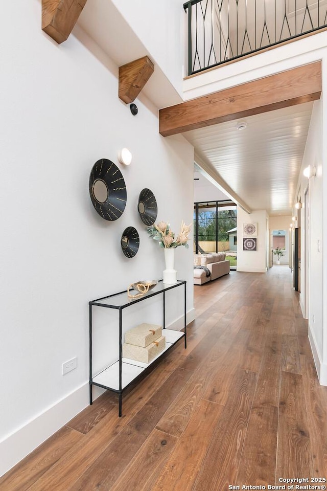 corridor featuring hardwood / wood-style flooring and beamed ceiling