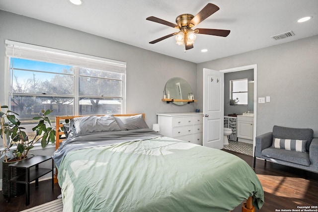 bedroom with connected bathroom, ceiling fan, and dark hardwood / wood-style floors