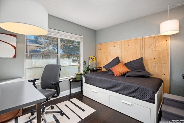 bedroom with dark hardwood / wood-style floors