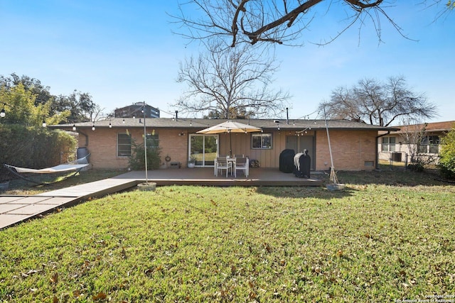 rear view of house with a yard and a wooden deck