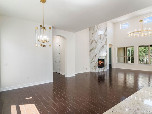 unfurnished living room with a premium fireplace and a notable chandelier