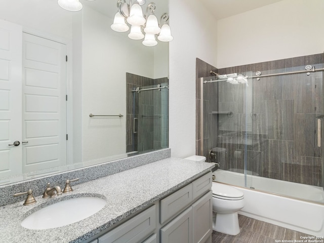 full bathroom featuring wood-type flooring, enclosed tub / shower combo, vanity, and toilet