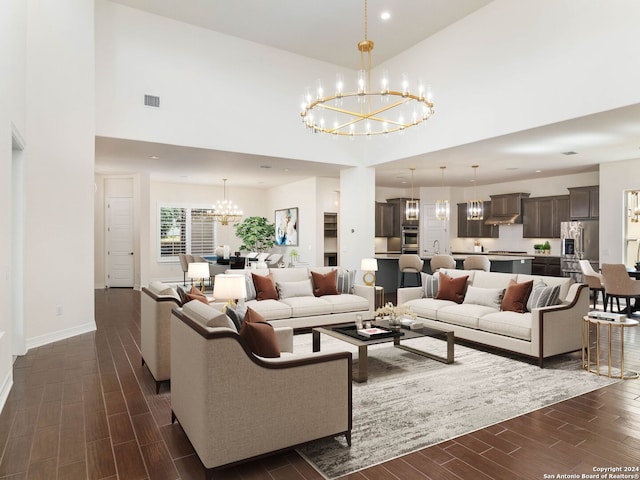 living room featuring high vaulted ceiling and an inviting chandelier