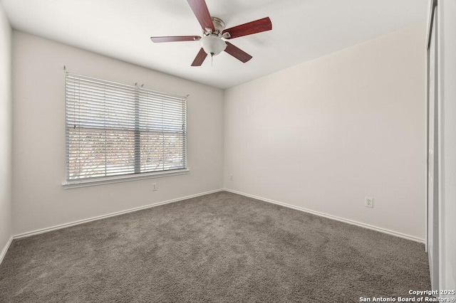 empty room featuring ceiling fan and dark colored carpet