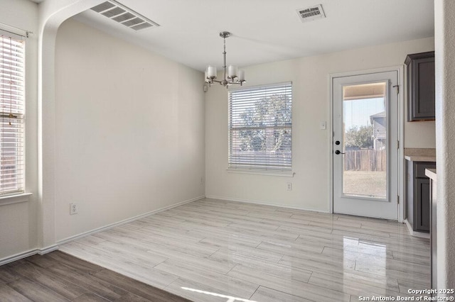 unfurnished dining area featuring a chandelier