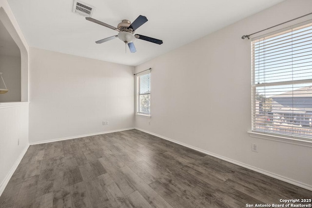 empty room with ceiling fan and dark wood-type flooring