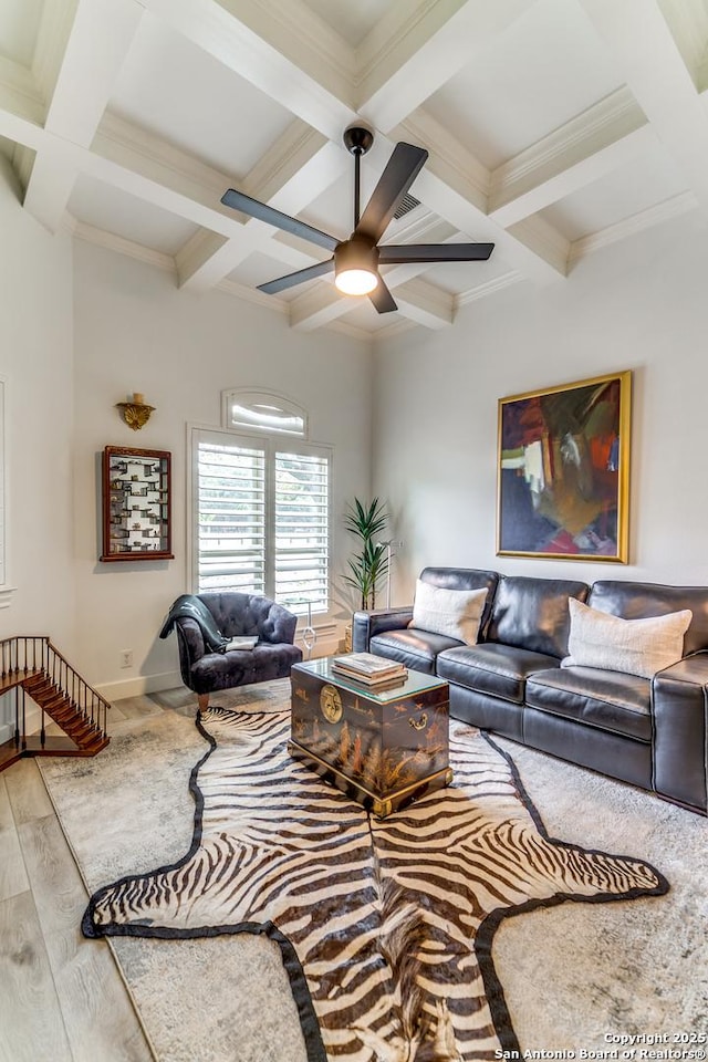 living room with ornamental molding, light wood-type flooring, beam ceiling, and ceiling fan