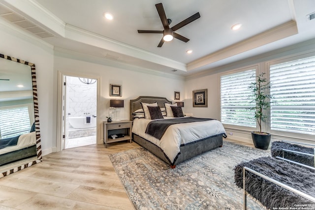 bedroom with light hardwood / wood-style floors, ceiling fan, a tray ceiling, and ornamental molding