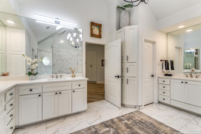 bathroom with lofted ceiling, walk in shower, vanity, and a notable chandelier