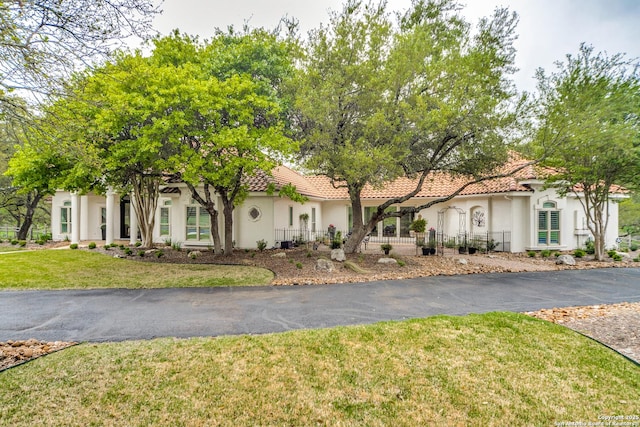 mediterranean / spanish home featuring a front lawn