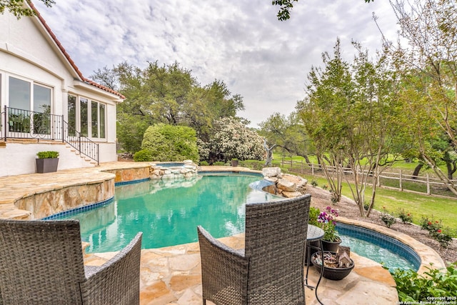 view of swimming pool with an in ground hot tub