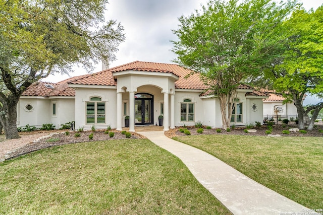 mediterranean / spanish house featuring french doors and a front lawn