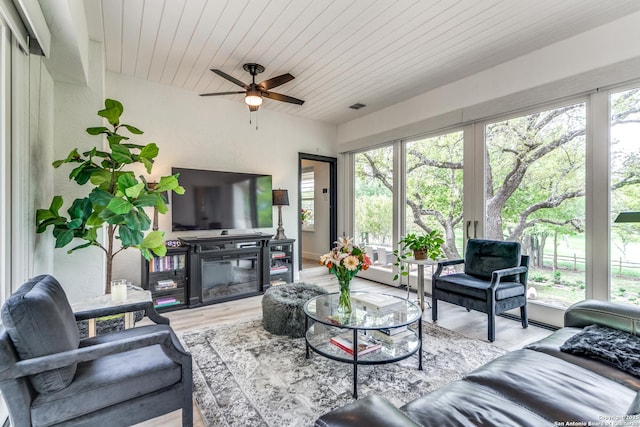 living room with wooden ceiling, a wealth of natural light, and light hardwood / wood-style flooring