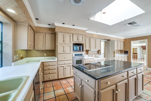 kitchen featuring a center island, a skylight, ornamental molding, and appliances with stainless steel finishes