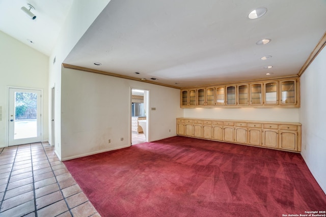 unfurnished living room featuring crown molding and dark colored carpet