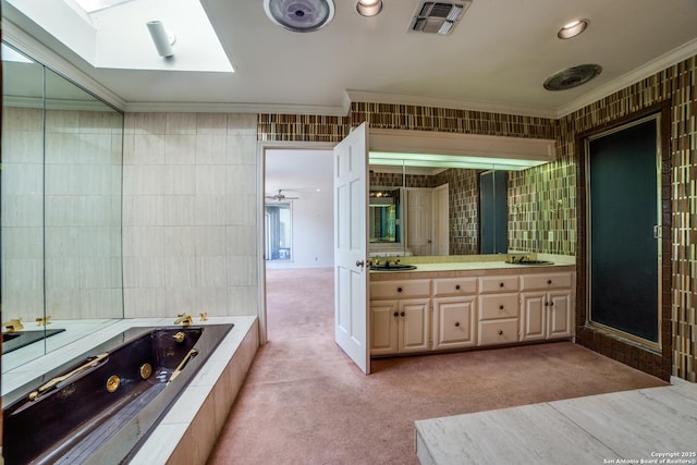 bathroom featuring shower with separate bathtub, tile walls, a skylight, vanity, and crown molding