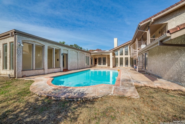 view of swimming pool featuring a patio and a yard