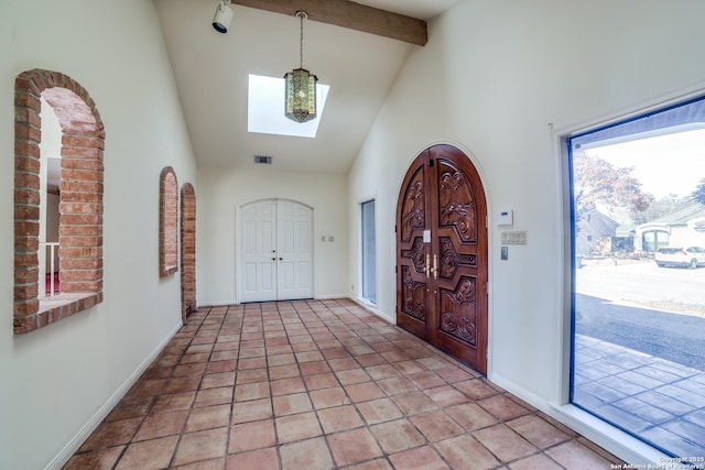 foyer entrance with high vaulted ceiling and beamed ceiling