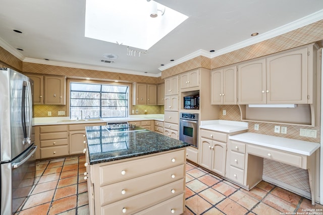 kitchen with a kitchen island, a skylight, crown molding, and appliances with stainless steel finishes