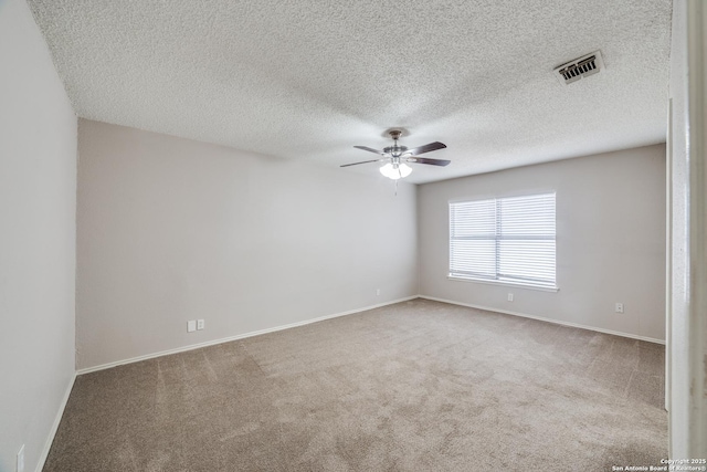 spare room featuring ceiling fan, carpet, and a textured ceiling