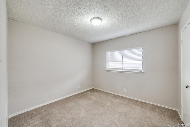 carpeted spare room featuring a textured ceiling