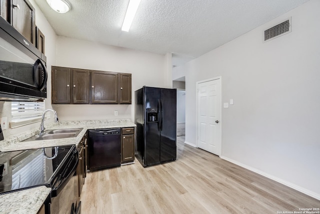 kitchen featuring a textured ceiling, black appliances, light wood-type flooring, dark brown cabinetry, and sink