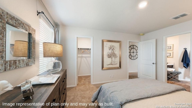 bedroom featuring a closet, a spacious closet, and light carpet