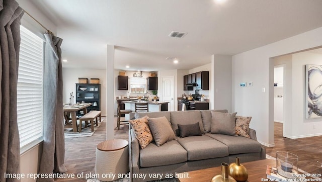 living room featuring sink, plenty of natural light, and dark hardwood / wood-style floors