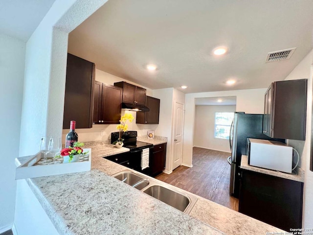 kitchen with kitchen peninsula, dark wood-type flooring, sink, black range with electric cooktop, and dark brown cabinetry