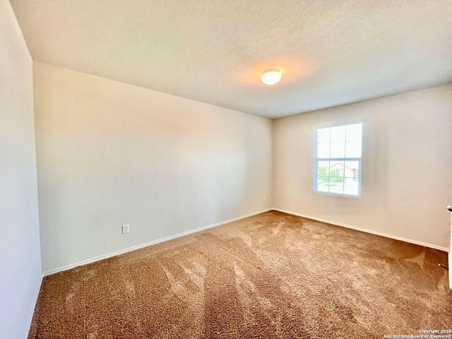 carpeted empty room featuring a textured ceiling