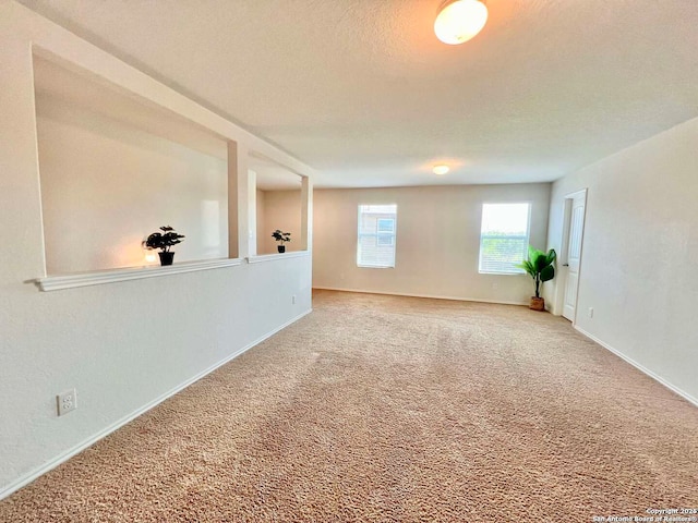 unfurnished room with a textured ceiling and carpet