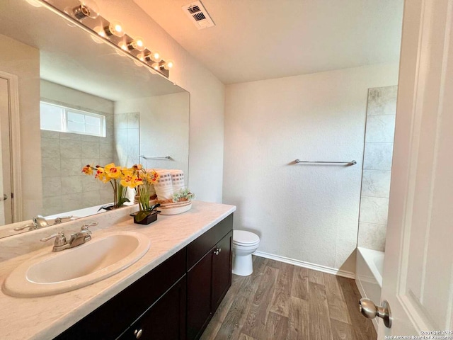 bathroom featuring walk in shower, toilet, vanity, and wood-type flooring