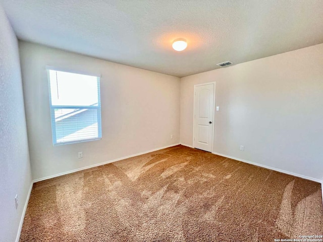 carpeted spare room with a textured ceiling