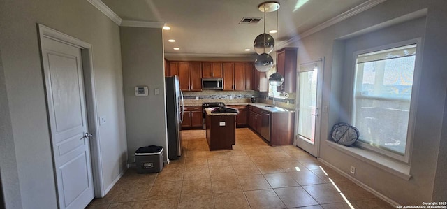 kitchen featuring stainless steel appliances, light tile patterned floors, pendant lighting, decorative backsplash, and sink