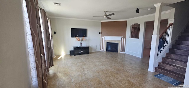 unfurnished living room with ornamental molding, ceiling fan, and a tiled fireplace