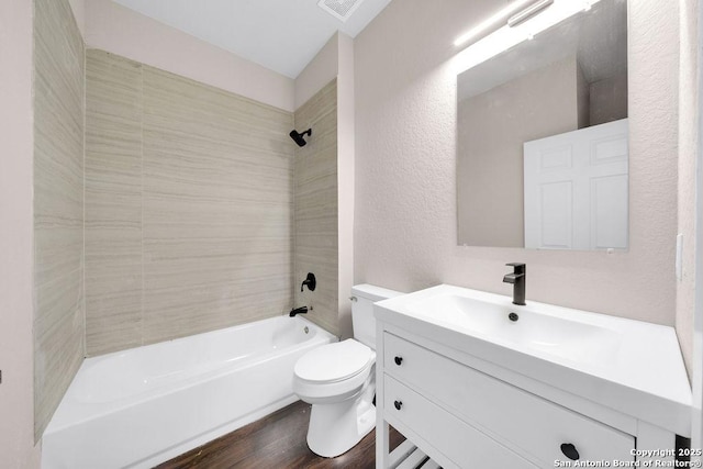 full bathroom featuring vanity, toilet, tiled shower / bath combo, and wood-type flooring