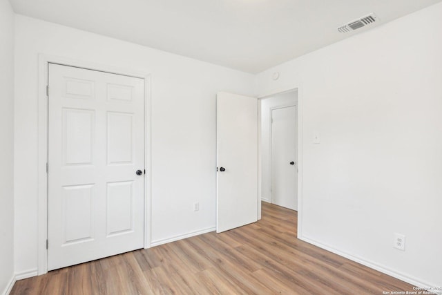 unfurnished bedroom featuring light wood-type flooring and a closet