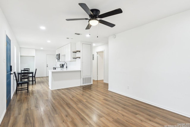 living room featuring sink, dark hardwood / wood-style flooring, and ceiling fan