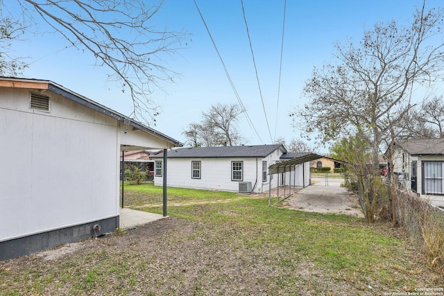 view of yard with a carport and central AC unit